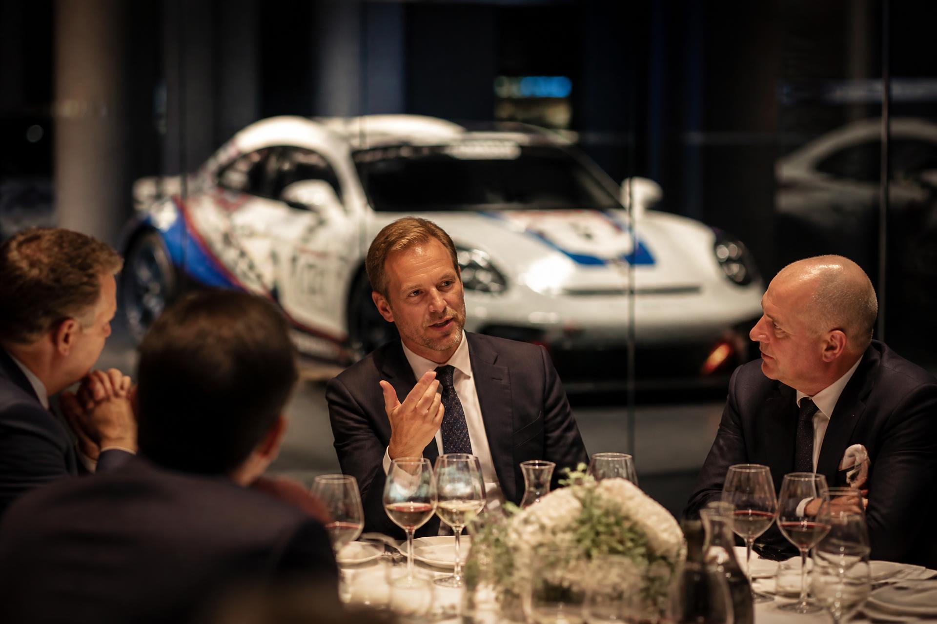 Business executives dining together in a Porsche showroom